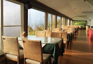 a dining room with tables and chairs and windows at Top Cloud Villa in Renai +14 photos