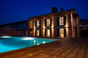 a house with a swimming pool at night at Agrisuite Il Cedro in La Morra