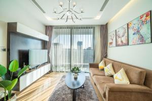 ハノイにあるBOM HOMES- VINHOMES METROPOLIS-Service Apartmentのソファとテレビのあるリビングルーム