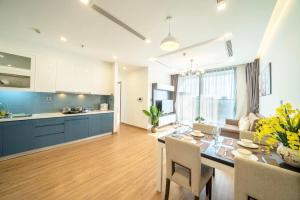 ハノイにあるBOM HOMES- VINHOMES METROPOLIS-Service Apartmentのテーブルと椅子のあるキッチンとダイニングルーム