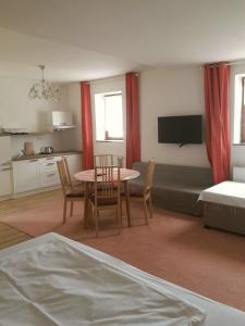 a living room with a table and chairs and a kitchen at Apartmány Sedmikráska in Tehovec