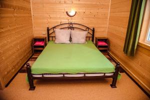 1 dormitorio pequeño con 1 cama verde y 2 sillas en Dom na beregu ozera Pleshcheevo 1 en Pereslavl-Zalesskiy