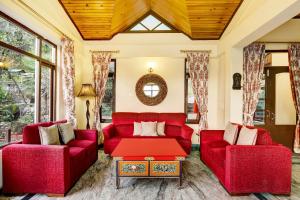 a living room with red furniture and a red table at Summit Norling Resort & Spa in Gangtok
