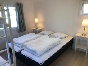 Un dormitorio con una cama grande con sábanas y almohadas blancas. en Trelleborg Strand, en Trelleborg