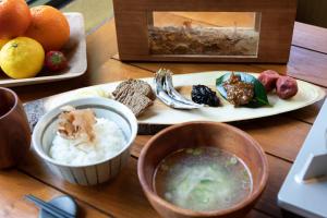 una mesa con un plato de comida y un tazón de sopa en Riverside Lodge, en Matsuno-cho