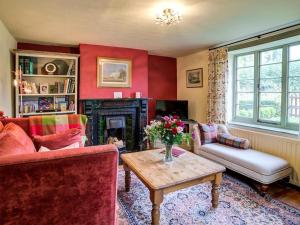 a living room with red walls and a fireplace at Elm View in Chipping Campden