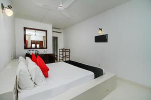 a bedroom with a white bed with red pillows at Kalla Bongo Lake Resort in Hikkaduwa +40 photos