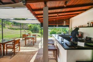 an outdoor kitchen with a bar and a patio at Kalla Bongo Lake Resort in Hikkaduwa