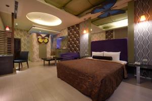 um quarto de hotel com uma cama, uma mesa e cadeiras em Sun Garden Motel em Kaohsiung
