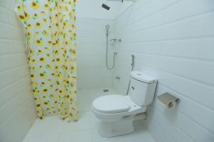 e bagno con servizi igienici e tenda doccia con girasoli. di Trinco Star Cabana a Trincomalee