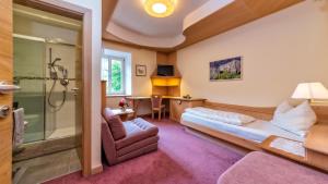 een hotelkamer met een bed en een douche bij Hotel Brückenwirt in Novacella