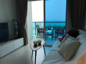 een woonkamer met een bank, een tv en een tafel bij GrandBlue Condominium Mae Phim TOP FLOOR WITH SEA VIEW 706 in Mae Pim