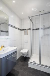een badkamer met een douche, een wastafel en een toilet bij Haus Inselzeit in Norderney