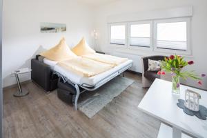 1 dormitorio con cama, escritorio y mesa en Haus Inselzeit, en Norderney