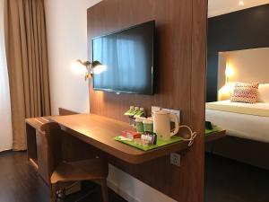 a hotel room with a desk and a bed at Campanile Shanghai Bund Hotel in Shanghai