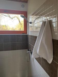 a bathroom with a white towel hanging on the wall at Piejūras Kempings in Ventspils
