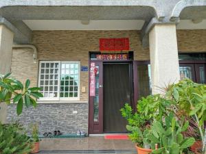 ein Gebäude mit einer roten Tür und einem Fenster in der Unterkunft Jin Xi Fu B&B in Jinning
