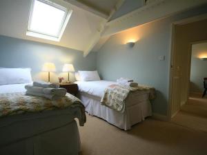ein Schlafzimmer mit zwei Betten und einem Fenster in der Unterkunft Cider Press Cottage in Priston