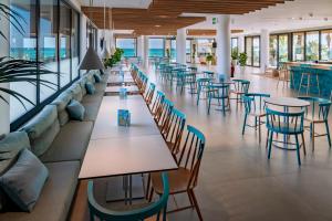 Caprici Beach Hotel & Spa في سانتا سوزانا: صف من الطاولات والكراسي في المطعم