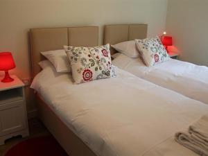 a bedroom with two beds with pillows and a red lamp at The Milking Parlour in Shaftesbury