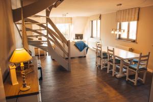 a dining room and living room with a staircase and a table at Residentie Duindoorn in Koksijde