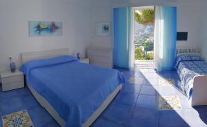 a blue bedroom with a bed and a window at Maridea - Finestrella in Ponza