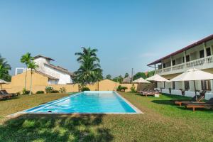 a swimming pool in front of a building at Kalla Bongo Lake Resort in Hikkaduwa
