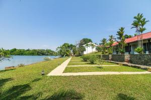 a walkway leading to a house next to the water at Kalla Bongo Lake Resort in Hikkaduwa