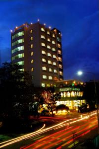 a tall building at night with a street in front at Bamboo Green Central Hotel in Danang