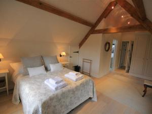 a bedroom with a bed with two towels on it at Hillside Cottage in Burford