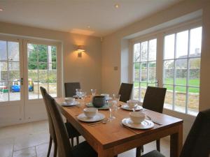 a dining room with a wooden table with chairs at Hillside Cottage in Burford