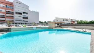 une grande piscine en face d'un bâtiment dans l'établissement Vacancéole - Résidence Le Saint Clair, au Cap d'Agde