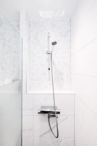 a shower in a bathroom with white tiles at West 7 in Zandvoort +15 photos