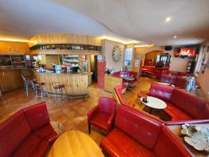 a restaurant with red leather seats and a bar at Hostel Novak in Novo Mesto