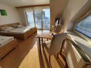 a bedroom with two beds and a table with a laptop at Hostel Novak in Novo Mesto