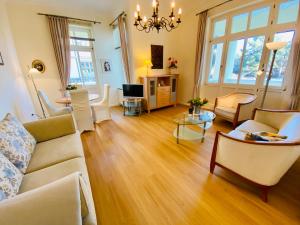 ein Wohnzimmer mit einem Sofa und einem Tisch in der Unterkunft Villa Caprivi - Ferienwohnung 3 in Heringsdorf