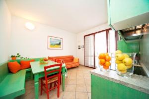 un salon avec une table et une cuisine verte dans l'établissement Dorado 8P, à Lido di Spina