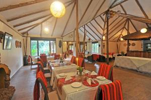 a restaurant with tables and chairs in a room at Gorilla Safari Lodge in Rubuguli