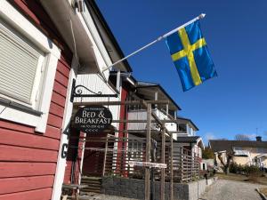 eine Flagge, die an der Seite eines Gebäudes hängt in der Unterkunft Sven Fredriksson Bed & Breakfast in Norrtälje
