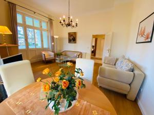 una sala de estar con una mesa con un jarrón de flores. en Villa Caprivi - Ferienwohnung 3, en Heringsdorf