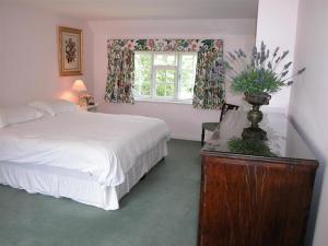 a bedroom with a bed and a window at Winterbourne Cottage in Chilmark