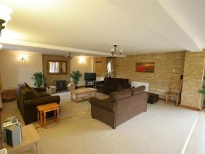 a living room with two couches and a tv at Tithe Barn, Lyneham in Bruern