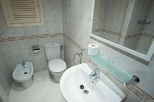 a bathroom with a sink and a toilet and a mirror at Hostal Mayol in Santa Eularia des Riu