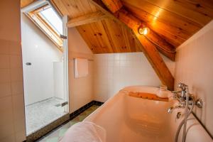 a bathroom with a large tub and a shower at B&B De Postoari Terschelling in Hoorn