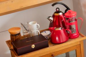 a wooden shelf with a red tea kettle and a box at B&B De Postoari Terschelling in Hoorn