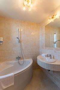 莫德尼卡的住宿－瑪格瑞塔酒店，带浴缸、水槽和镜子的浴室