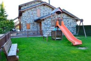 a playground with a slide in front of a building at Casa adosada con piscina en Agoustrina in Angoustrine