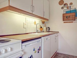- une cuisine avec des placards blancs et un évier dans l'établissement 4 person holiday home in Gudhjem, à Gudhjem