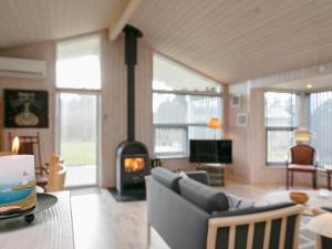 uma sala de estar com um sofá e uma lareira em 7 person holiday home in Hj rring em Hjørring