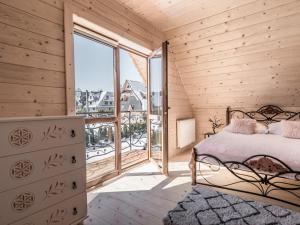 um quarto com uma cama e uma grande janela em DOMKI GALANTÓWKA em Zakopane